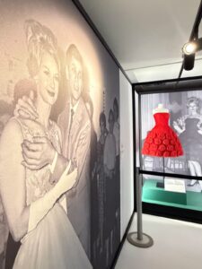 Mostra Moda in Luce 1955-1975 alla Centrale Montemartini di Roma con fotografie d’epoca e abito rosso esposto